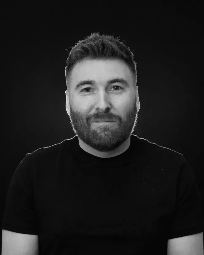 Black and white portrait of Liam Fallen in a dark T-shirt.